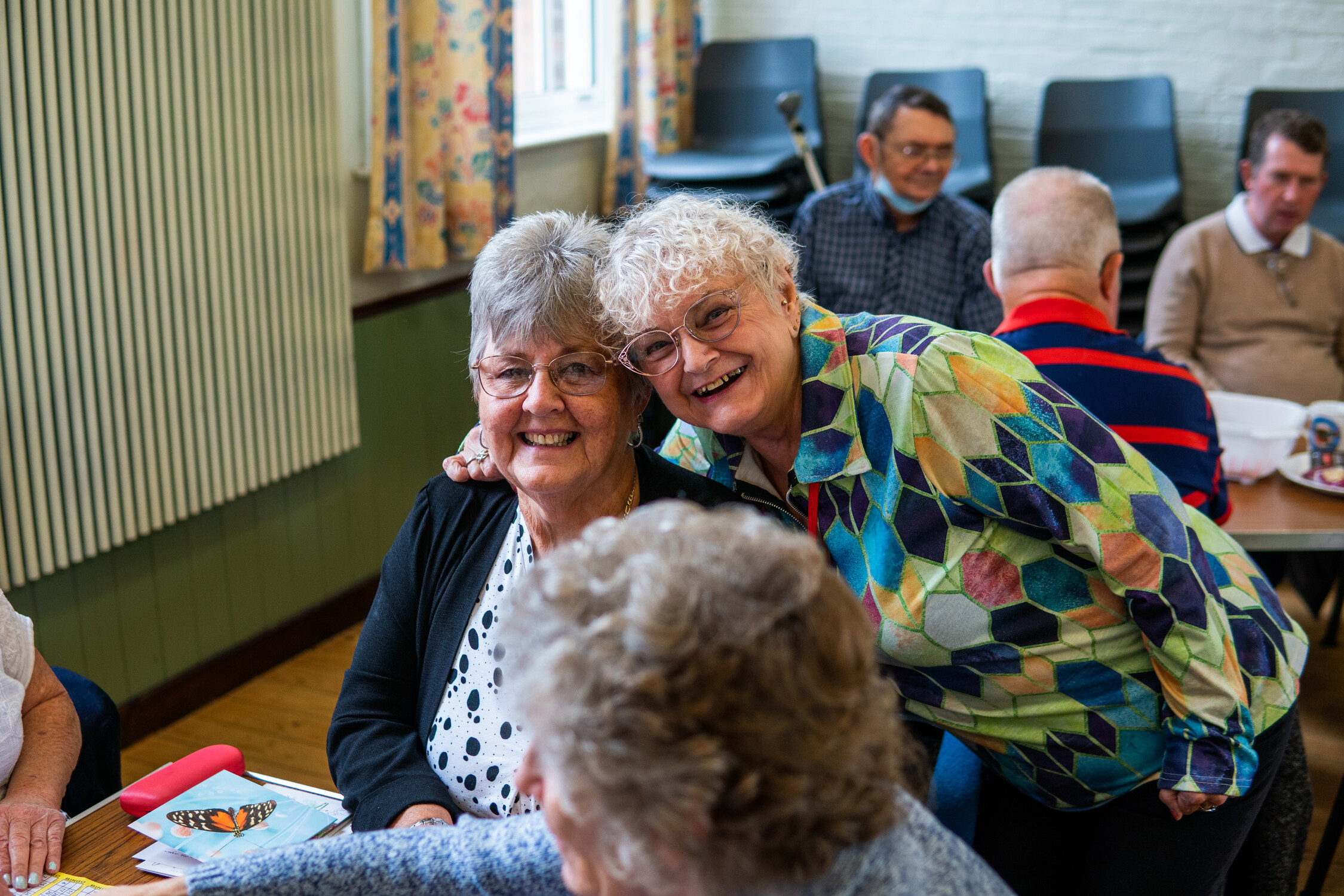 A group of woman in a community centre smile at the camera