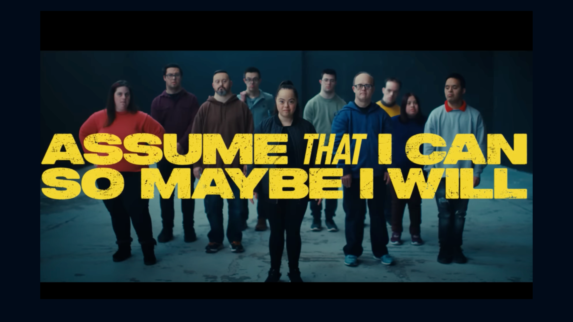 A image of the video - Assume that I can so maybe I will. With people in the background.