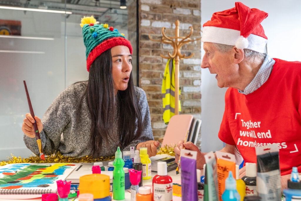 People in Christmas hats eat a meal