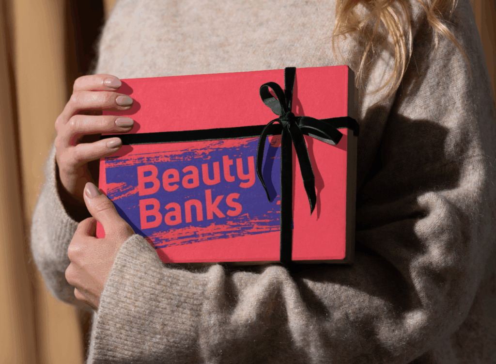 A woman holds a gift bearing the words Beauty Banks