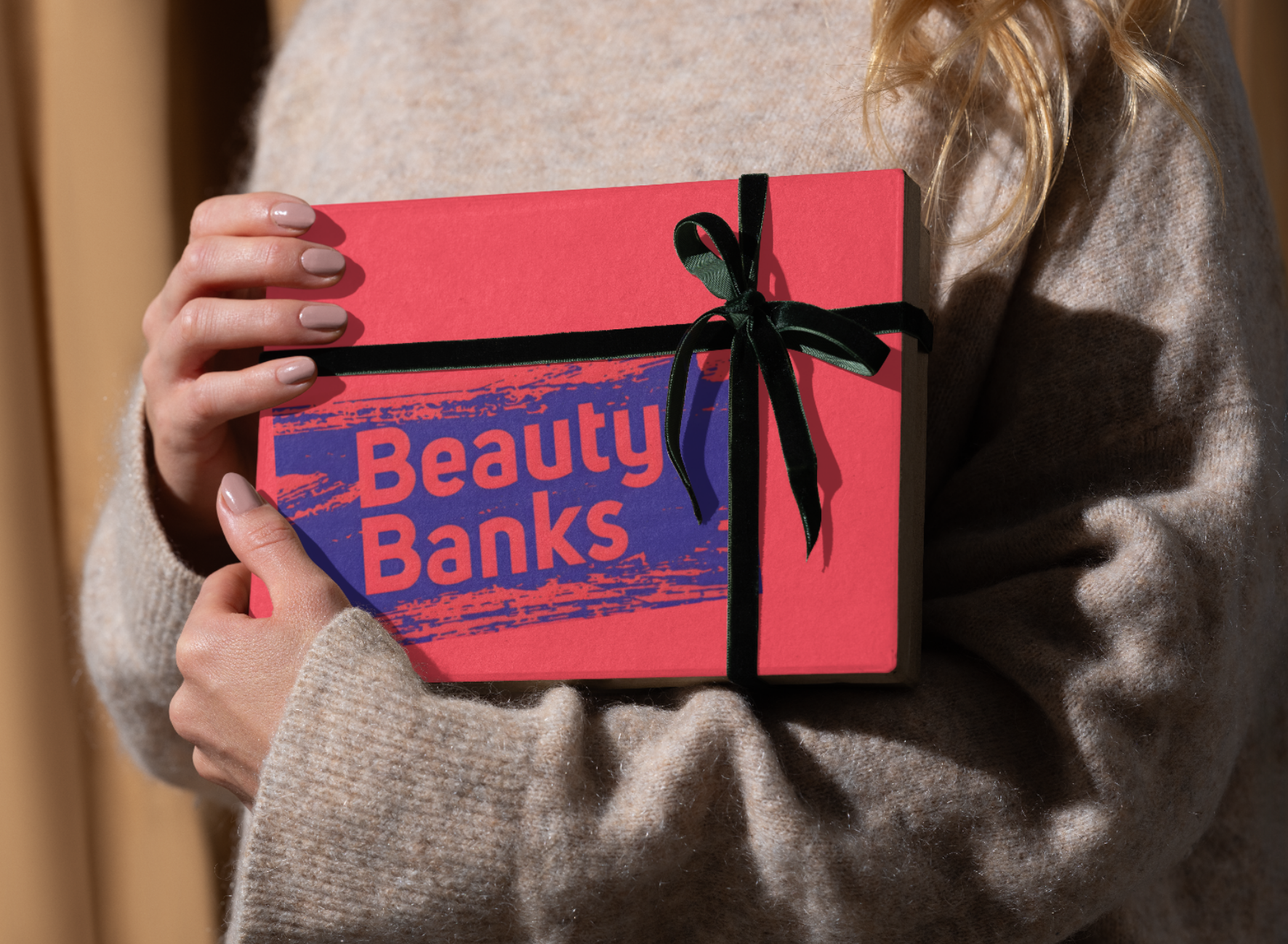 A woman holds a gift bearing the words Beauty Banks