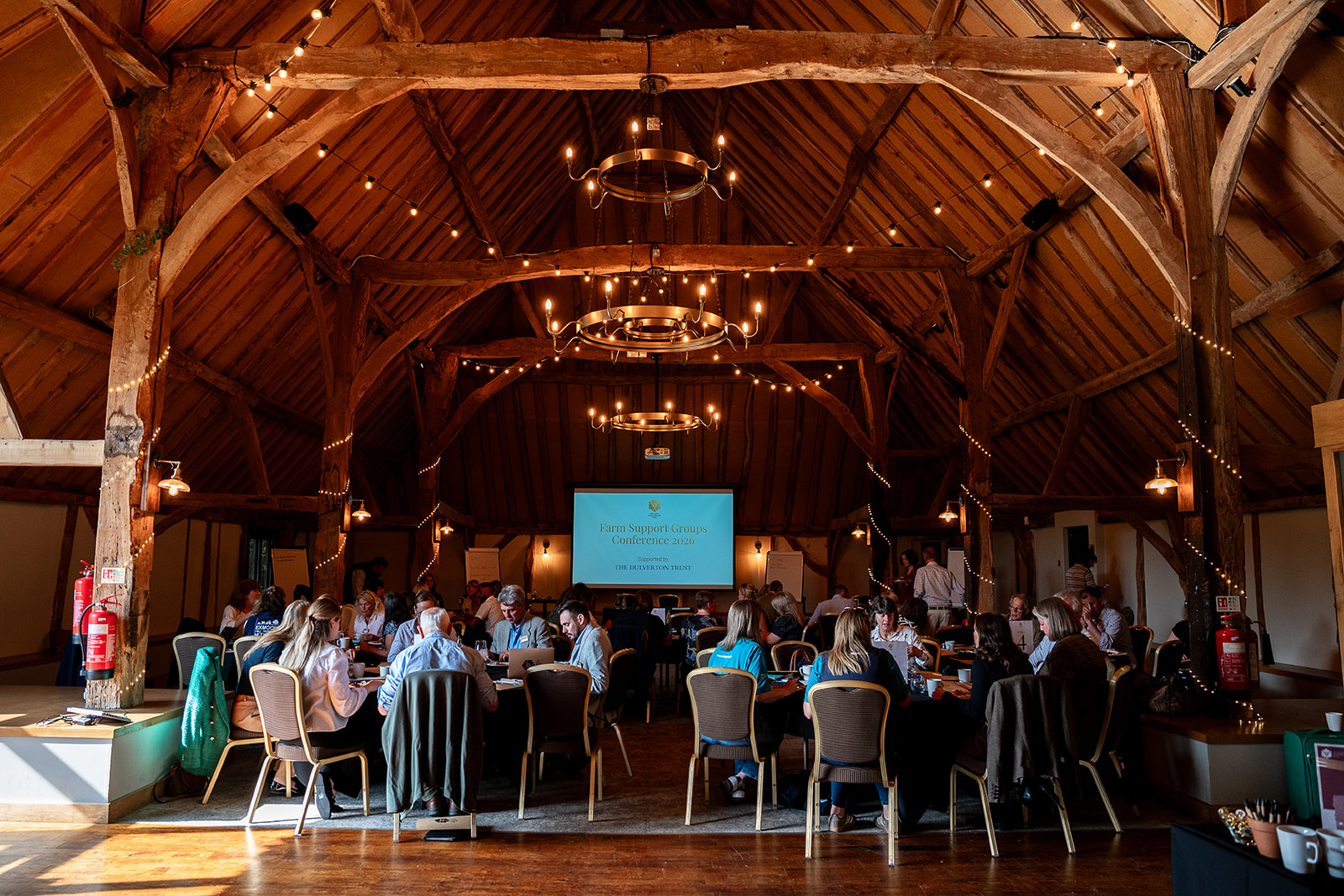 A group at a conference in a stylish barn hall